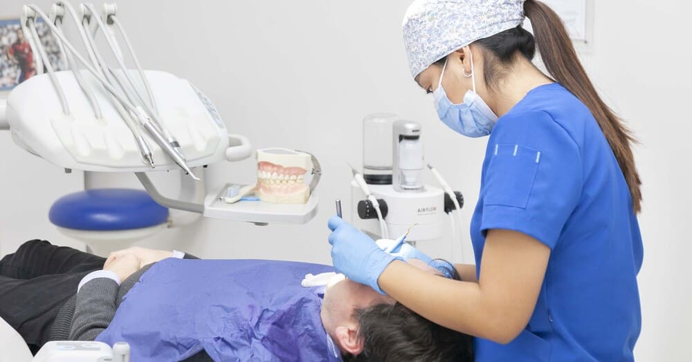 examinando boca paciente odontologa